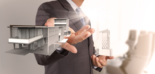 businessman hand presents house model on modern computer